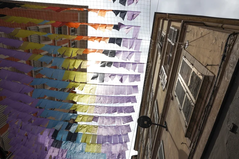 Vue sur l'installation de tissus colorés accrochée en haut de bâtiments